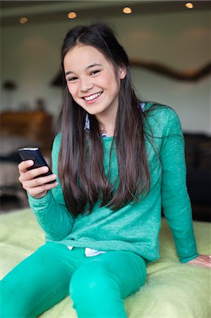 Portrait d'une jeune fille à l'aide d'un téléphone mobile Photographie de stock - Premium Libres de Droits, Code: 6108-06167304