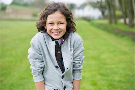 Portrait of a boy smiling in a field Stock Photo - Premium Royalty-Free, Code: 6108-06167331