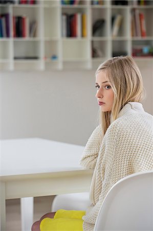 Serious woman sitting in a room Stock Photo - Premium Royalty-Free, Code: 6108-06167449