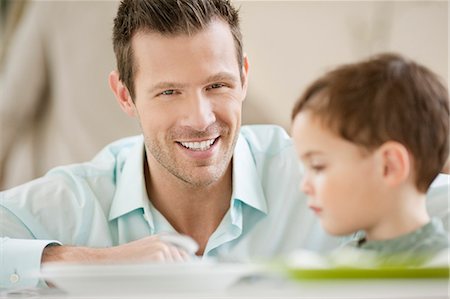 simsearch:6108-06167436,k - Homme avec son fils assis à une table à manger Photographie de stock - Premium Libres de Droits, Code: 6108-06167454