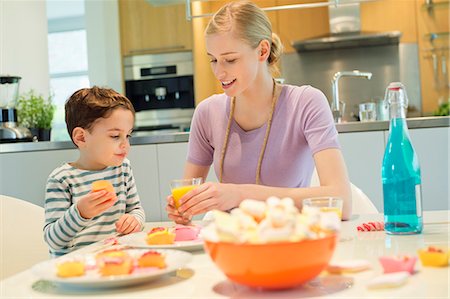 picture of person eating cake - Woman and son at breakfast table Stock Photo - Premium Royalty-Free, Code: 6108-06167401