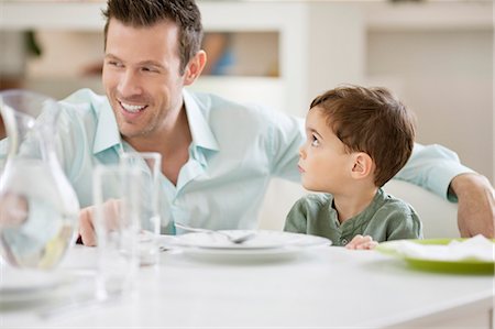 simsearch:6108-06167425,k - Man with his son sitting at a dining table Stock Photo - Premium Royalty-Free, Code: 6108-06167422