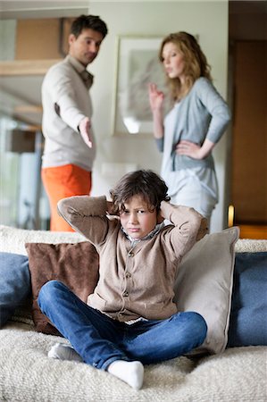 disputation - Boy covering ears with hands while his parents arguing in the background Stock Photo - Premium Royalty-Free, Code: 6108-06167546