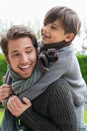 parents play kids - Happy boy riding piggyback on his father Stock Photo - Premium Royalty-Free, Code: 6108-06167553