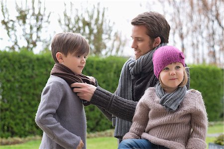 Man putting on warm clothing to his children Stock Photo - Premium Royalty-Free, Code: 6108-06167566