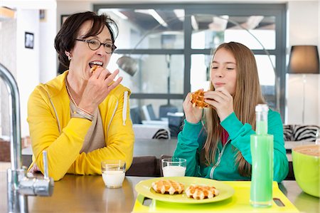 Elderly woman with her granddaughter eating waffles Stock Photo - Premium Royalty-Free, Code: 6108-06167641