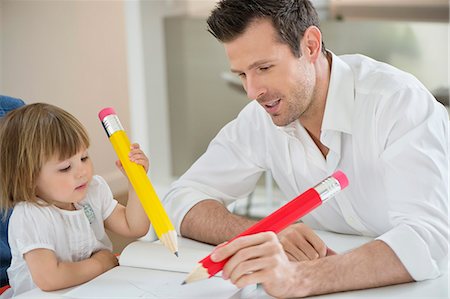 drawing picture on parents - Man and daughter writing with big pencils Stock Photo - Premium Royalty-Free, Code: 6108-06167601