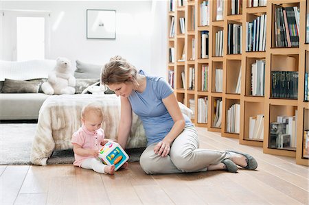 parkett - Frau sitzt in der Nähe ihrer Tochter mit einem Spielzeug spielen Stockbilder - Premium RF Lizenzfrei, Bildnummer: 6108-06167761