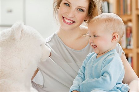 Baby girl playing with a teddy bear and smiling Stock Photo - Premium Royalty-Free, Code: 6108-06167783