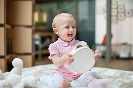 stuffed animal to baby - Baby girl playing with a tambourine Stock Photo - Premium Royalty-Free, Code: 6108-06167703