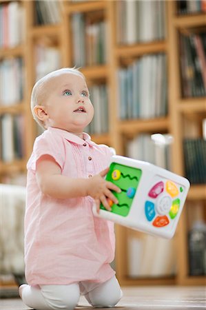 Baby girl playing with a musical block toy Stock Photo - Premium Royalty-Free, Code: 6108-06167705