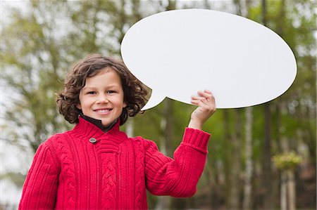 Portrait of a boy holding a speech bubble Stock Photo - Premium Royalty-Free, Code: 6108-06167868