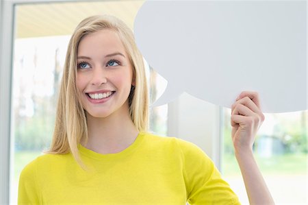 simsearch:6108-06167873,k - Woman holding a speech bubble and smiling Stock Photo - Premium Royalty-Free, Code: 6108-06167883