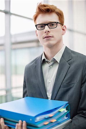 simsearch:6108-06167871,k - Portrait of a businessman holding files in an office Stock Photo - Premium Royalty-Free, Code: 6108-06167810