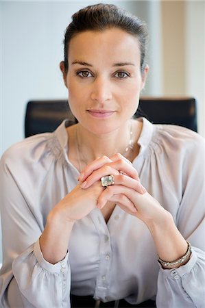 portrait business woman confident - Portrait of a businesswoman with her hands clasped in an office Stock Photo - Premium Royalty-Free, Code: 6108-06167821