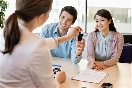 Couple receiving keys from business executive Stock Photo - Premium Royalty-Free, Code: 6108-06167959