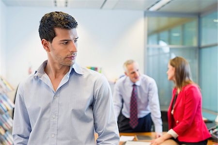 simsearch:6108-06168085,k - Male executive listening to his colleagues conversation in an office Foto de stock - Sin royalties Premium, Código: 6108-06167997