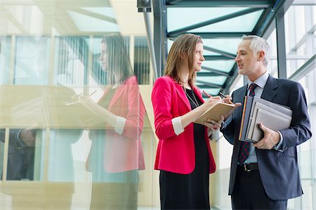 signing a check - Business executives discussing in an office corridor Stock Photo - Premium Royalty-Free, Code: 6108-06167995