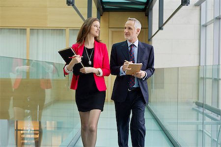 report file - Business executives discussing in an office corridor Stock Photo - Premium Royalty-Free, Code: 6108-06168042