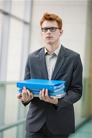 simsearch:6108-06168361,k - Portrait of a businessman holding files in an office Fotografie stock - Premium Royalty-Free, Codice: 6108-06168058