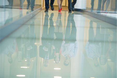 Reflection of business executives on the glassy floor Stock Photo - Premium Royalty-Free, Code: 6108-06168081