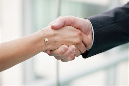 shaking hands two people - Close-up of business executives shaking hands in an office Stock Photo - Premium Royalty-Free, Code: 6108-06168017