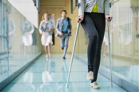 running in corridors - Disabled woman walking with a man and a woman running behind her Stock Photo - Premium Royalty-Free, Code: 6108-06168038