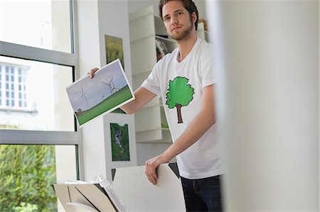 people holding a poster - Man holding an ecological poster showing wind turbine Stock Photo - Premium Royalty-Free, Code: 6108-06168140