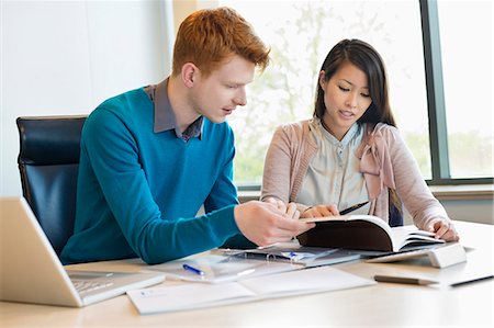 report file - Businessman examining documents with his secretary Stock Photo - Premium Royalty-Free, Code: 6108-06168166