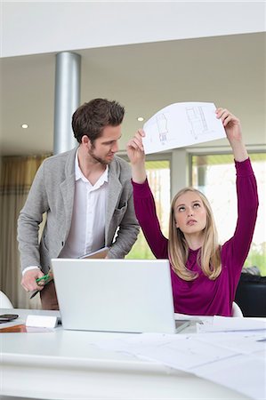 drafting - Woman examining an architectural design in the office Stock Photo - Premium Royalty-Free, Code: 6108-06168119