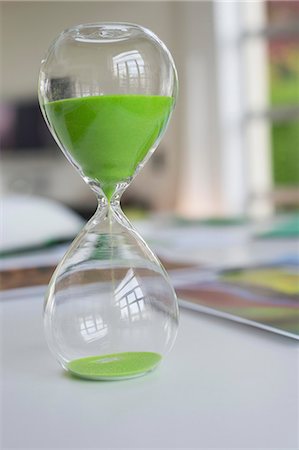 Close-up of an hourglass with green sand in it Stock Photo - Premium Royalty-Free, Code: 6108-06168372