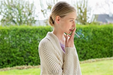 smoking (human activity) - Woman smoking cigarette in park Stock Photo - Premium Royalty-Free, Code: 6108-06168390