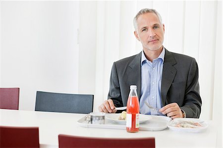 people eating on dining table - Businessman having lunch in the office Stock Photo - Premium Royalty-Free, Code: 6108-06168312