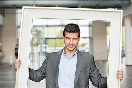simsearch:6108-06167871,k - Close-up of a businessman holding a frame in an office lobby Stock Photo - Premium Royalty-Free, Code: 6108-06168331