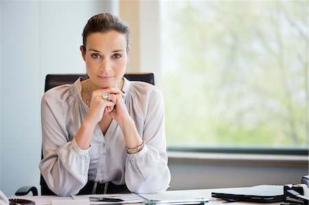 female sitting office chair - Portrait of a businesswoman in an office Stock Photo - Premium Royalty-Free, Code: 6108-06168334