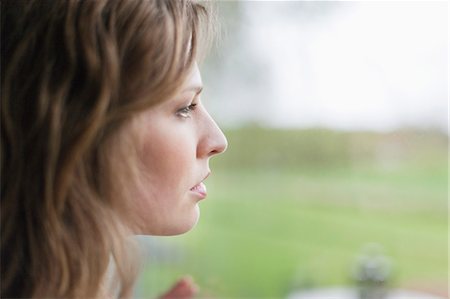 pensive woman glass - Woman looking through the glass of window Stock Photo - Premium Royalty-Free, Code: 6108-06168464