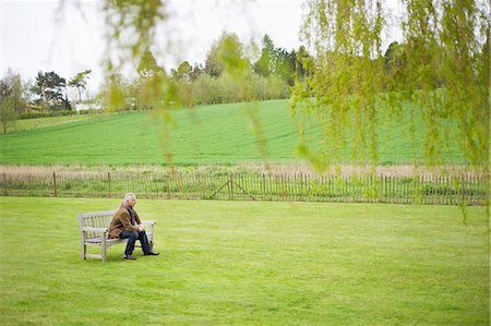 fenced - Man sitting on a bench in a field Stock Photo - Premium Royalty-Free, Code: 6108-06168485