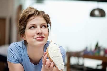 Gros plan d'une femme manger pain grillé avec de la crème diffuser sur elle Photographie de stock - Premium Libres de Droits, Code: 6108-06168411