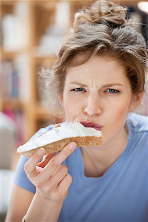 fromage blanc - Portrait of a woman eating toast with cream spread on it Foto de stock - Sin royalties Premium, Código: 6108-06168416