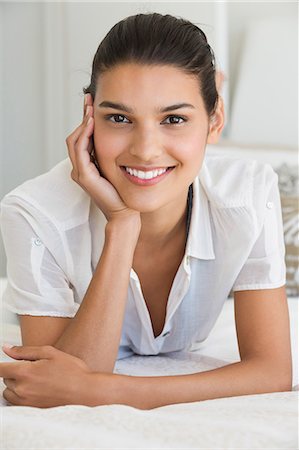 Portrait of a woman smiling on the bed Stock Photo - Premium Royalty-Free, Code: 6108-06904477