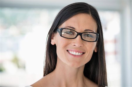 eyeglasses people smiling - Close-up of a woman smiling Stock Photo - Premium Royalty-Free, Code: 6108-06904481