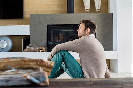 foyer - Man sitting in front of a fireplace at home Foto de stock - Sin royalties Premium, Código: 6108-06904541