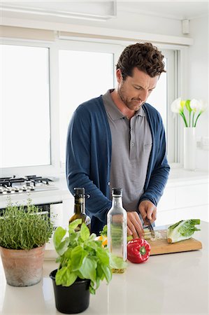 simsearch:6115-08066617,k - Man chopping vegetables in a kitchen Photographie de stock - Premium Libres de Droits, Code: 6108-06904547