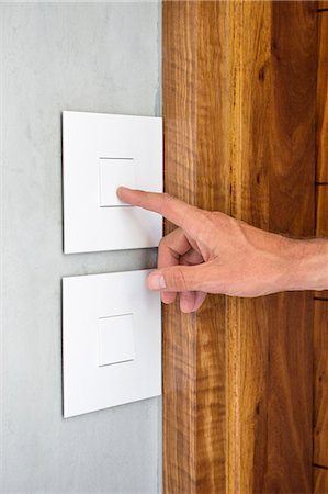 régulation - Close-up of a person's hand pressing a light switch Photographie de stock - Premium Libres de Droits, Code: 6108-06904545