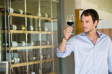 simsearch:6108-06905419,k - Man looking at red wine in a wineglass Stock Photo - Premium Royalty-Free, Code: 6108-06904562