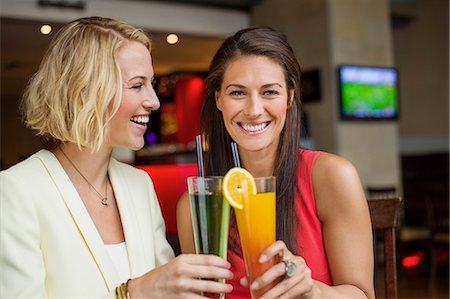 simsearch:6108-06166043,k - Two female friends enjoying drinks in a restaurant Foto de stock - Sin royalties Premium, Código: 6108-06904637