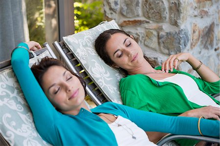 picture of lady on sleeping lounge chair - Two women relaxing on lounge chairs Stock Photo - Premium Royalty-Free, Code: 6108-06904636