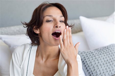 Woman yawning on the bed Stock Photo - Premium Royalty-Free, Code: 6108-06904743