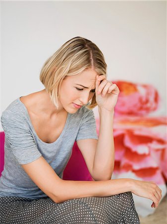 sad woman sitting in armchair - Woman sitting on an armchair and thinking Stock Photo - Premium Royalty-Free, Code: 6108-06904748