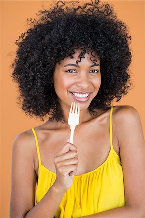 fork - Portrait of a woman holding a fork and smiling Stock Photo - Premium Royalty-Free, Code: 6108-06904753